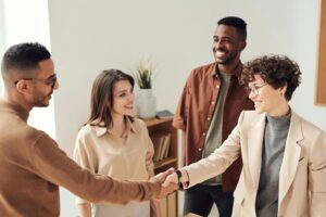 diverse group of professionals looking at each other, two shaking hands and smiling